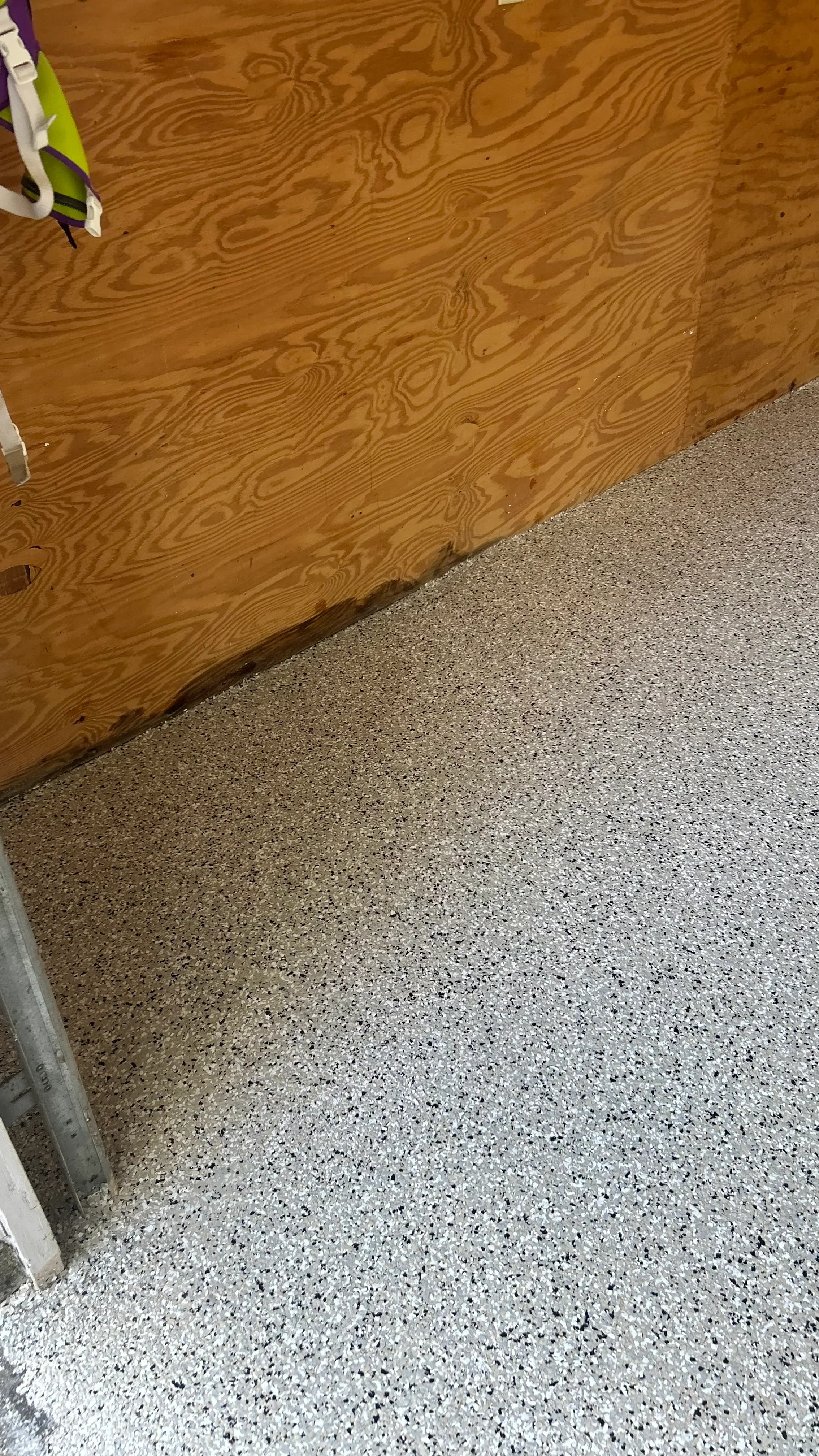 Polished concrete floor with light gray aggregate next to wood-grain epoxy wall coating
