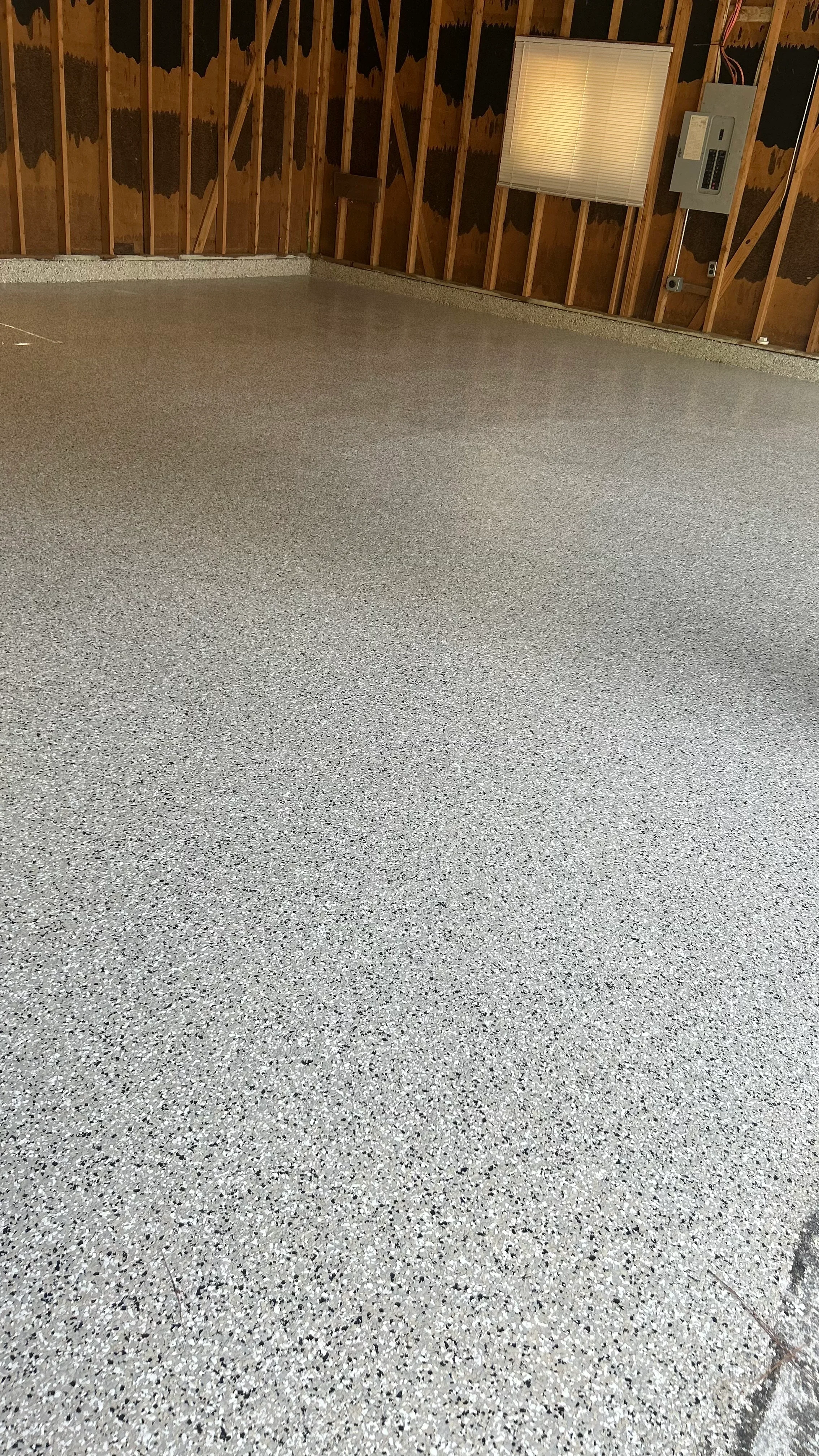Light gray speckled epoxy-coated concrete garage floor with seamless finish