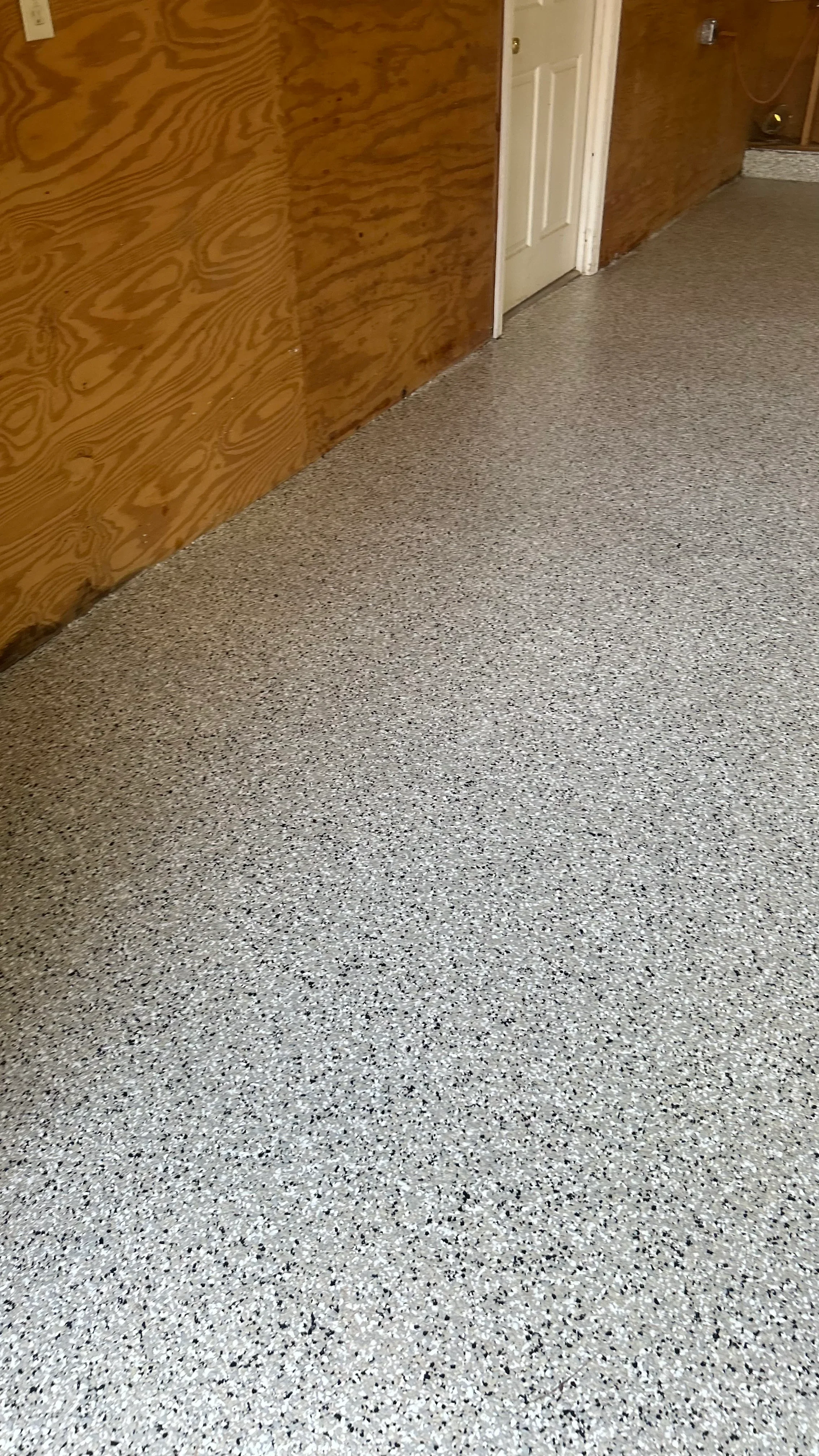Polished concrete floor with gray and black speckled aggregate finish in interior space