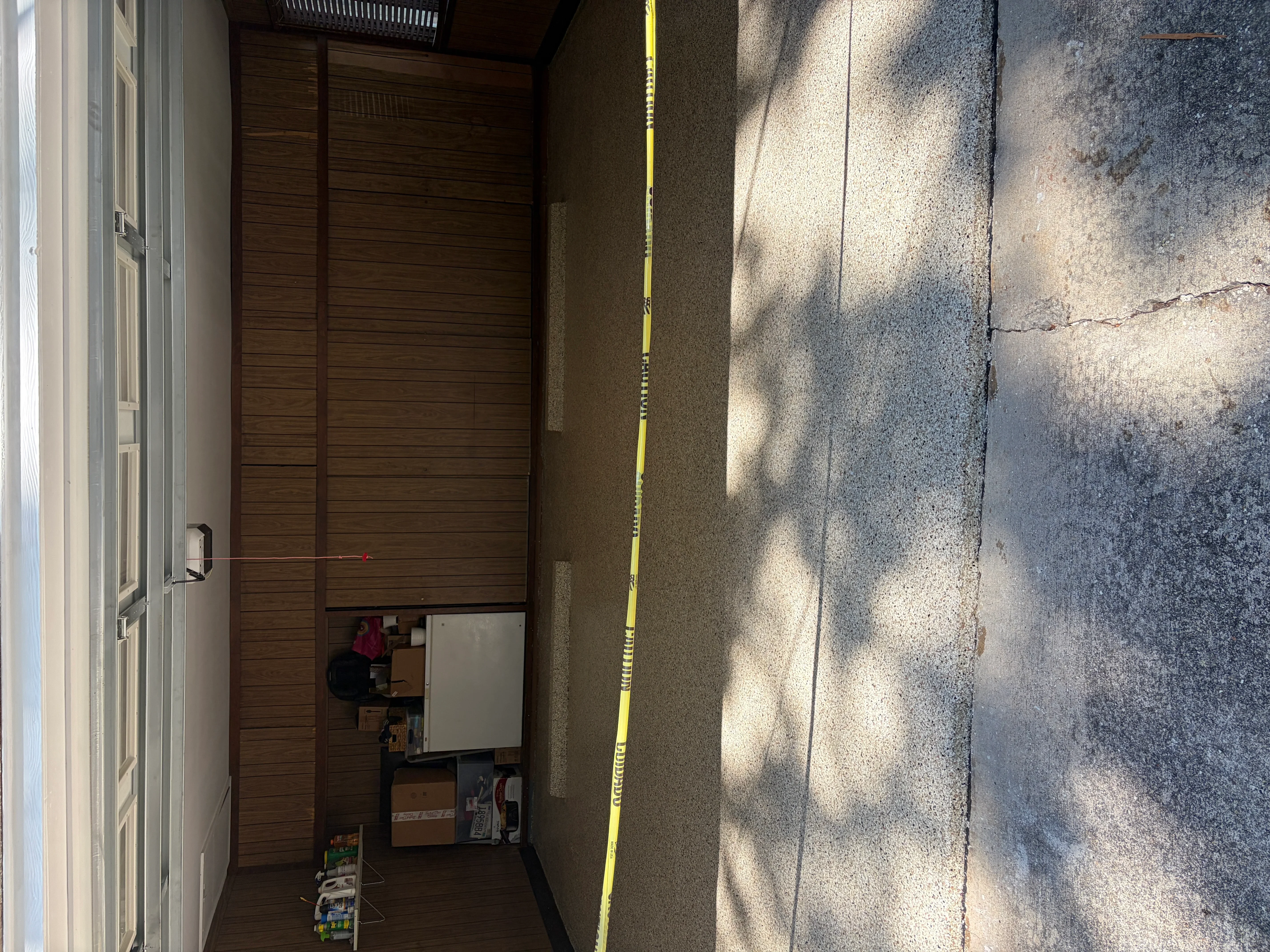 Concrete driveway with yellow measurement tape and garage door entry preparation