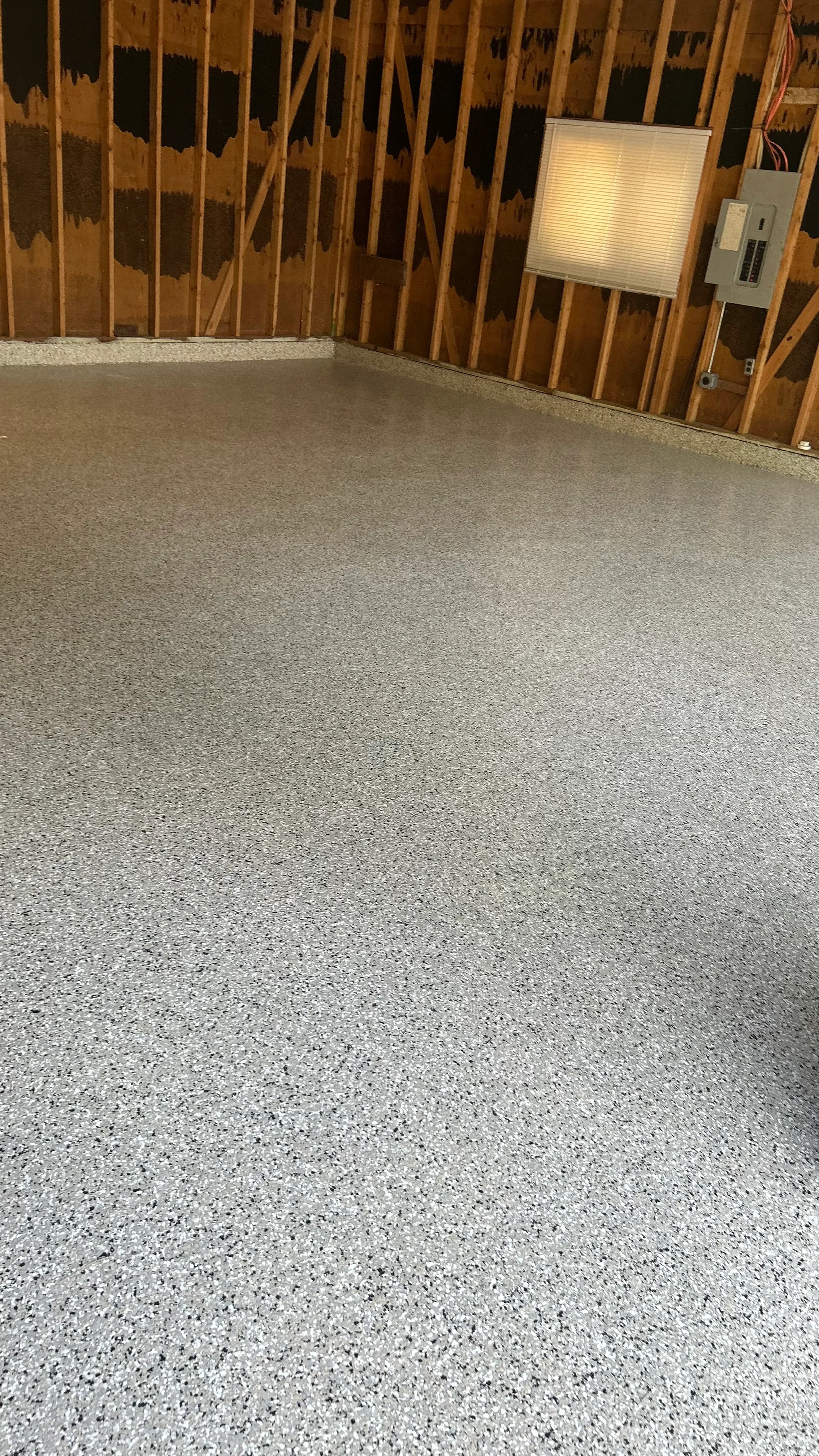 Polished concrete floor with exposed aggregate in light gray tone, smooth finish