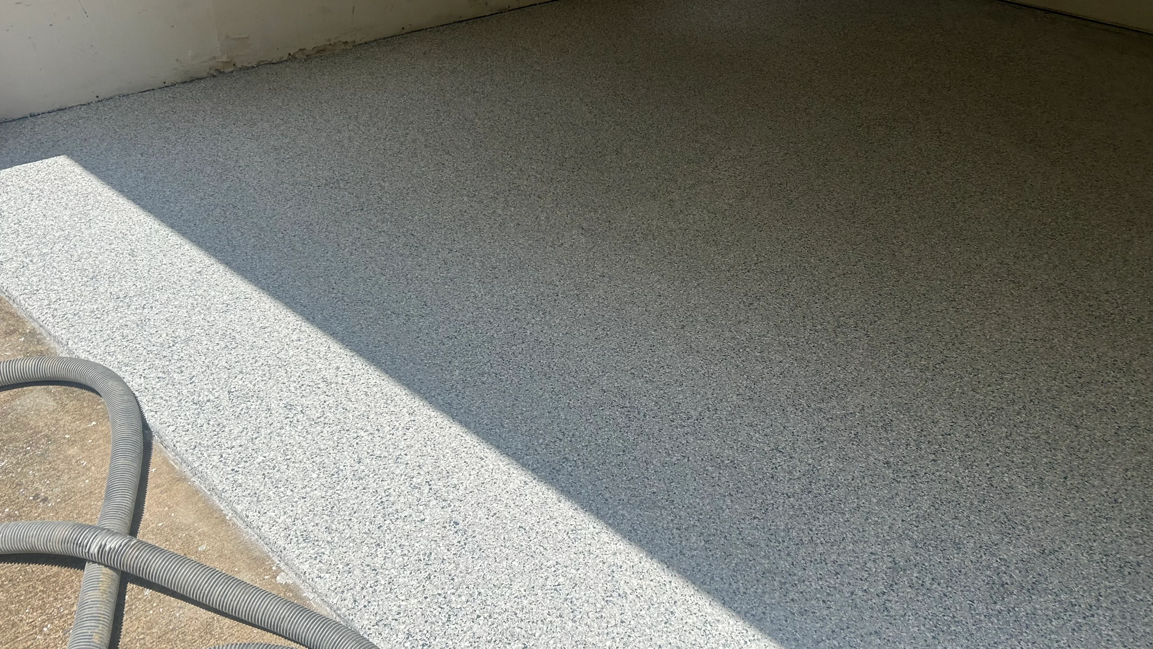Gray epoxy-coated garage floor with clean edges and uniform finish