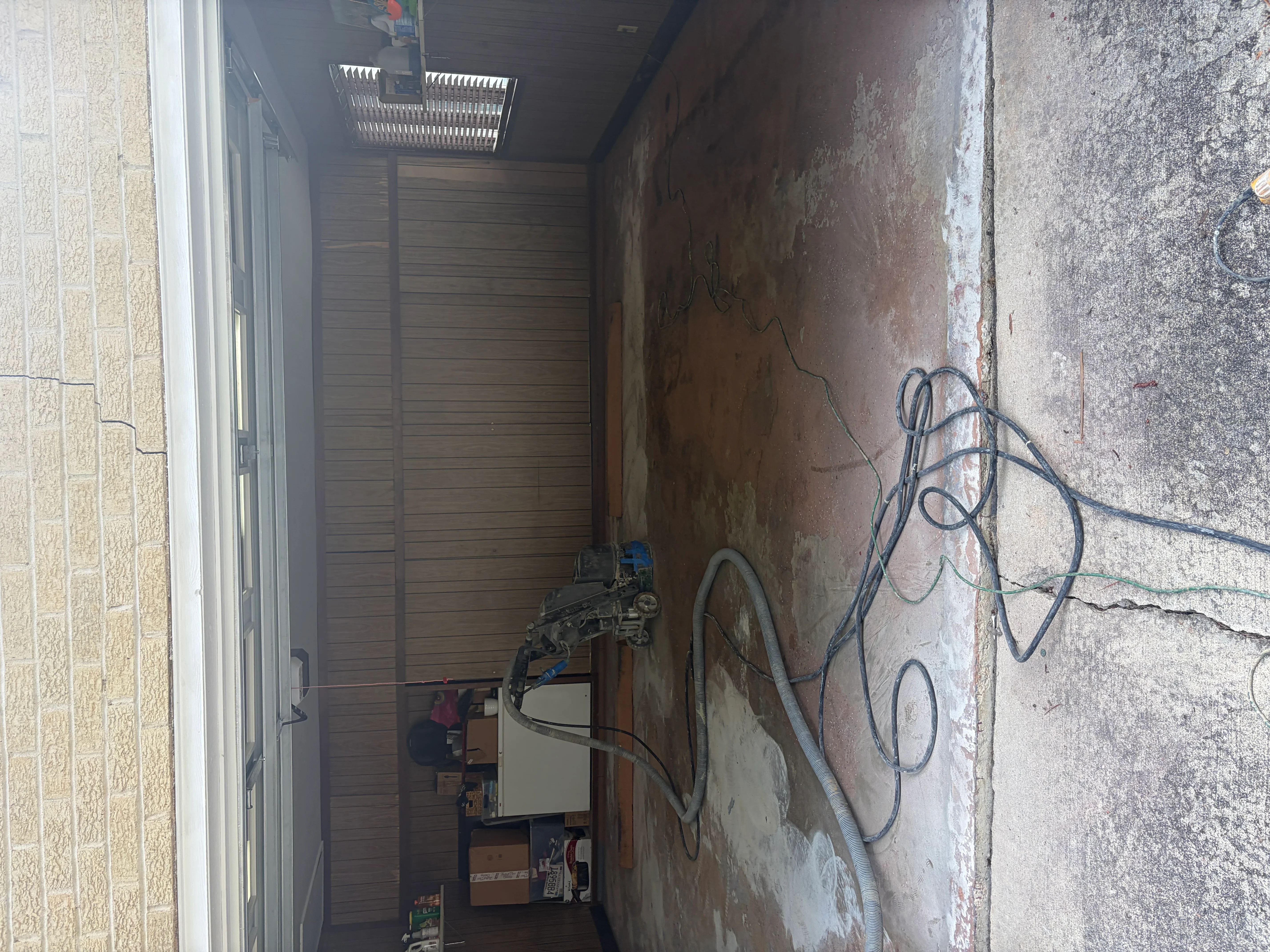 Garage interior with concrete floor prep, electrical conduit, and coating equipment setup