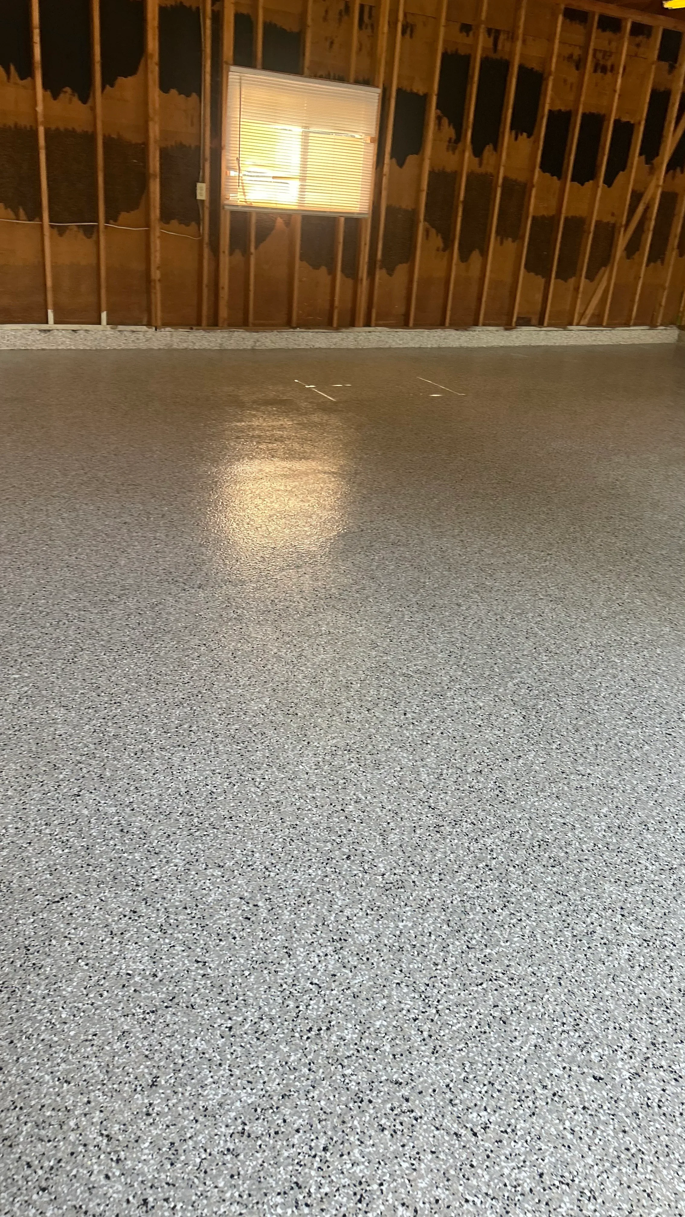 Polished concrete floor with gray aggregate and epoxy coating in commercial space