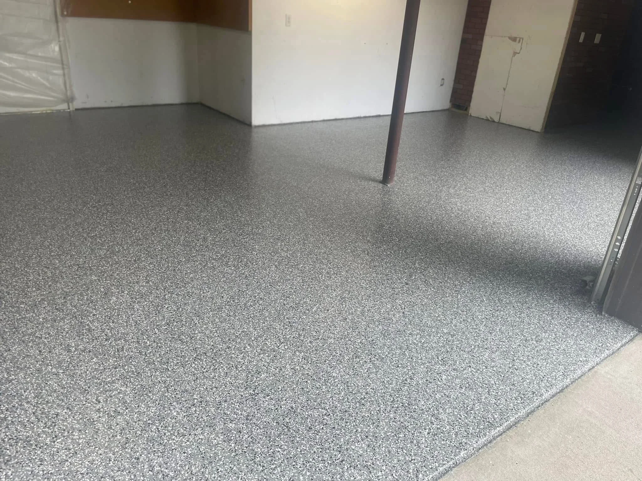 Gray speckled epoxy-coated garage floor with smooth, reflective finish