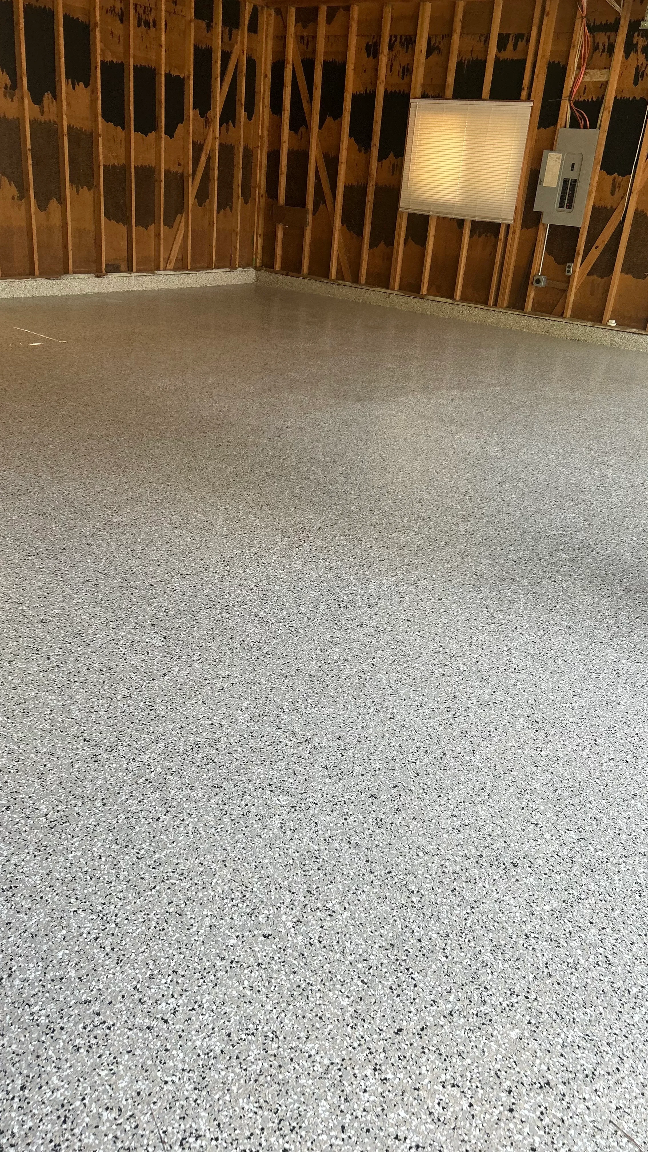 Light gray speckled epoxy-coated concrete garage floor with clean finish