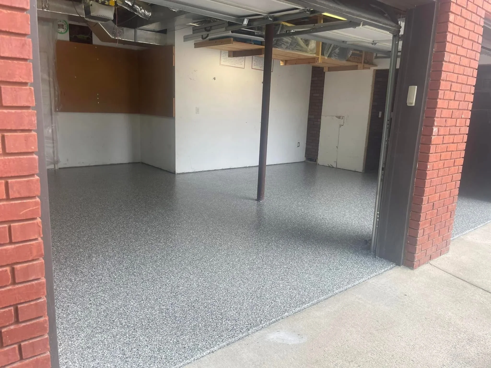 Gray speckled epoxy-coated garage floor with seamless finish and clean edge detail