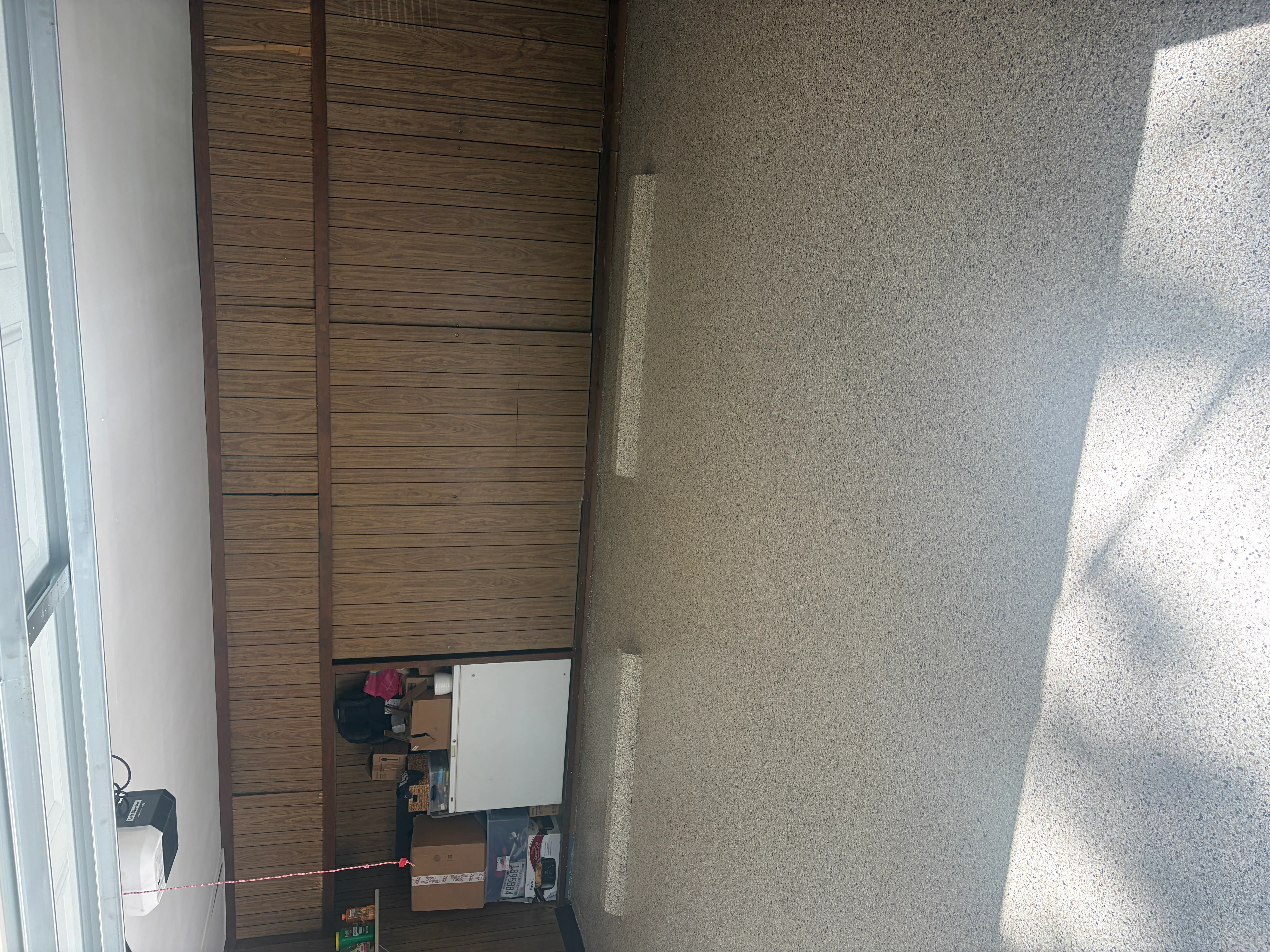 Finished concrete floor with aggregate surface in interior room with wood wall paneling