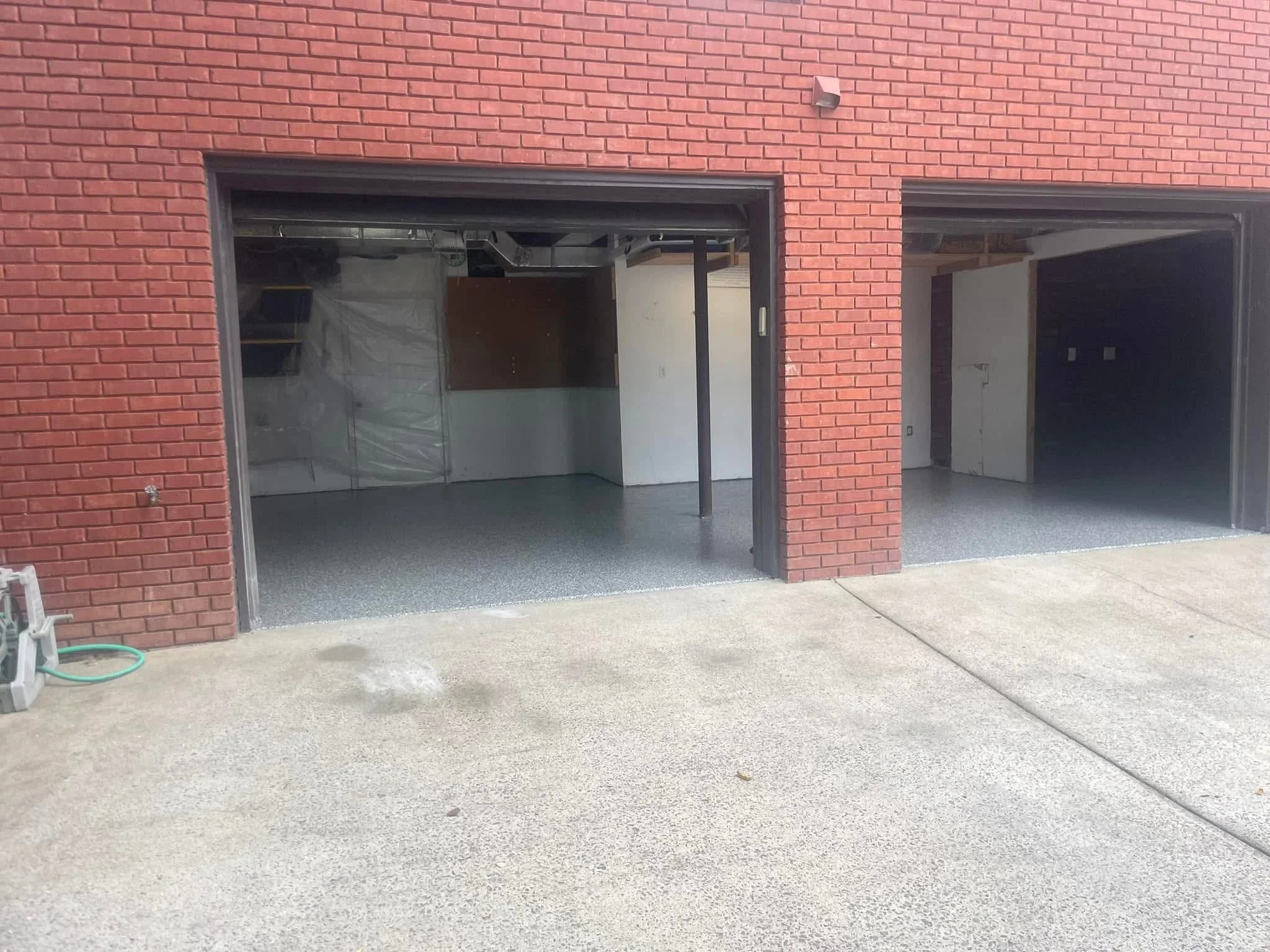 Finished garage floor with gray epoxy coating and dark garage door frames