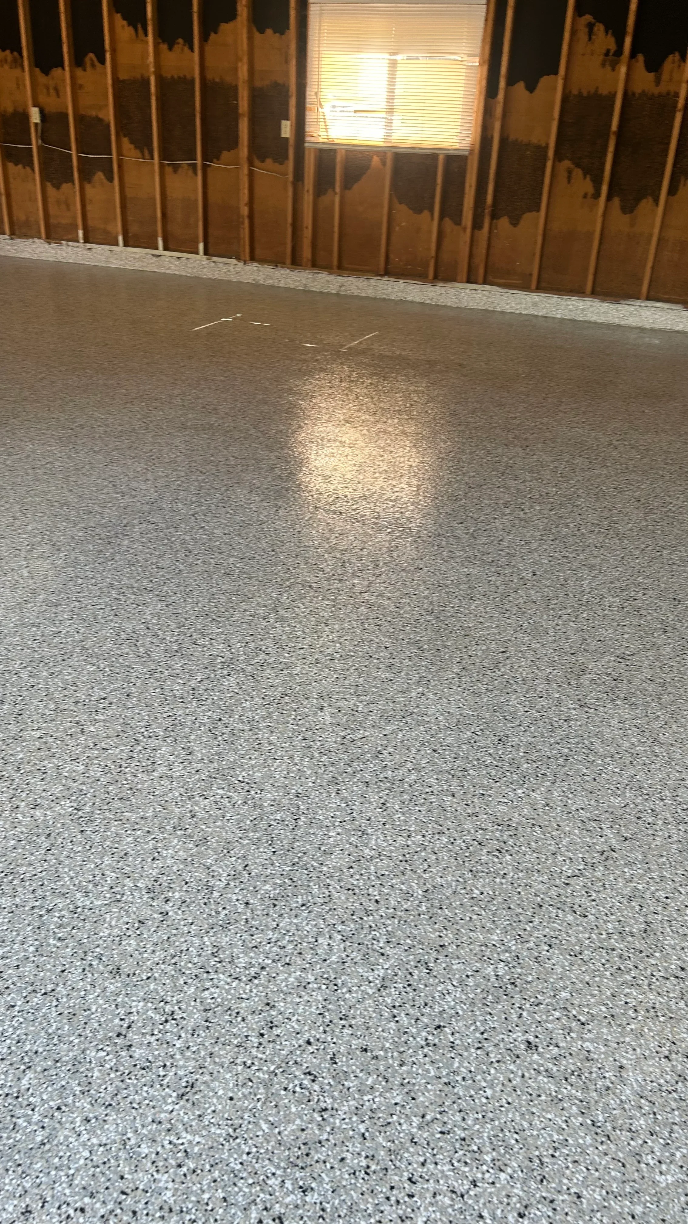 Polished concrete garage floor with gray aggregate and glossy finish
